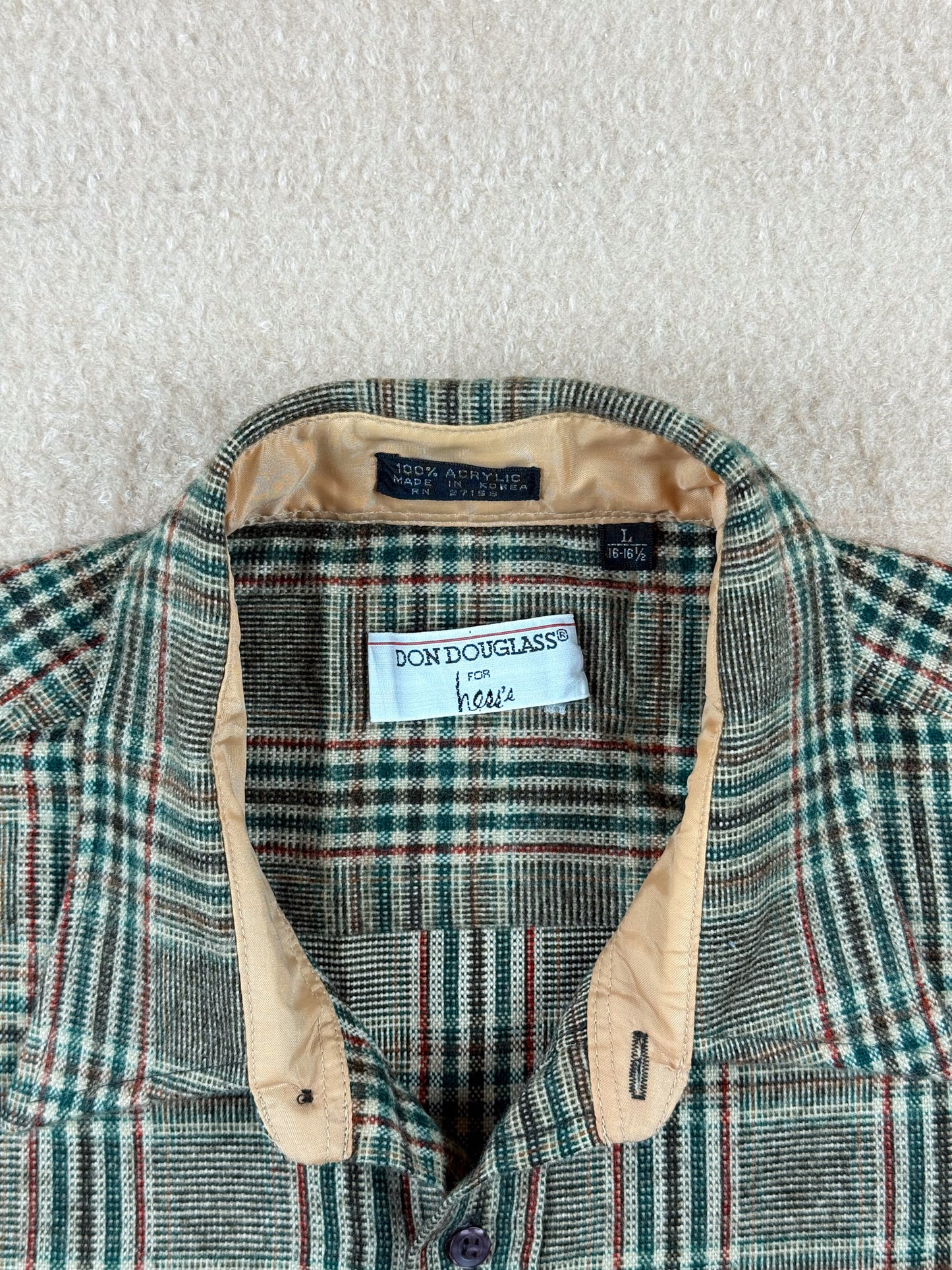 Plaid shirt with a visible brand label on a textured surface
