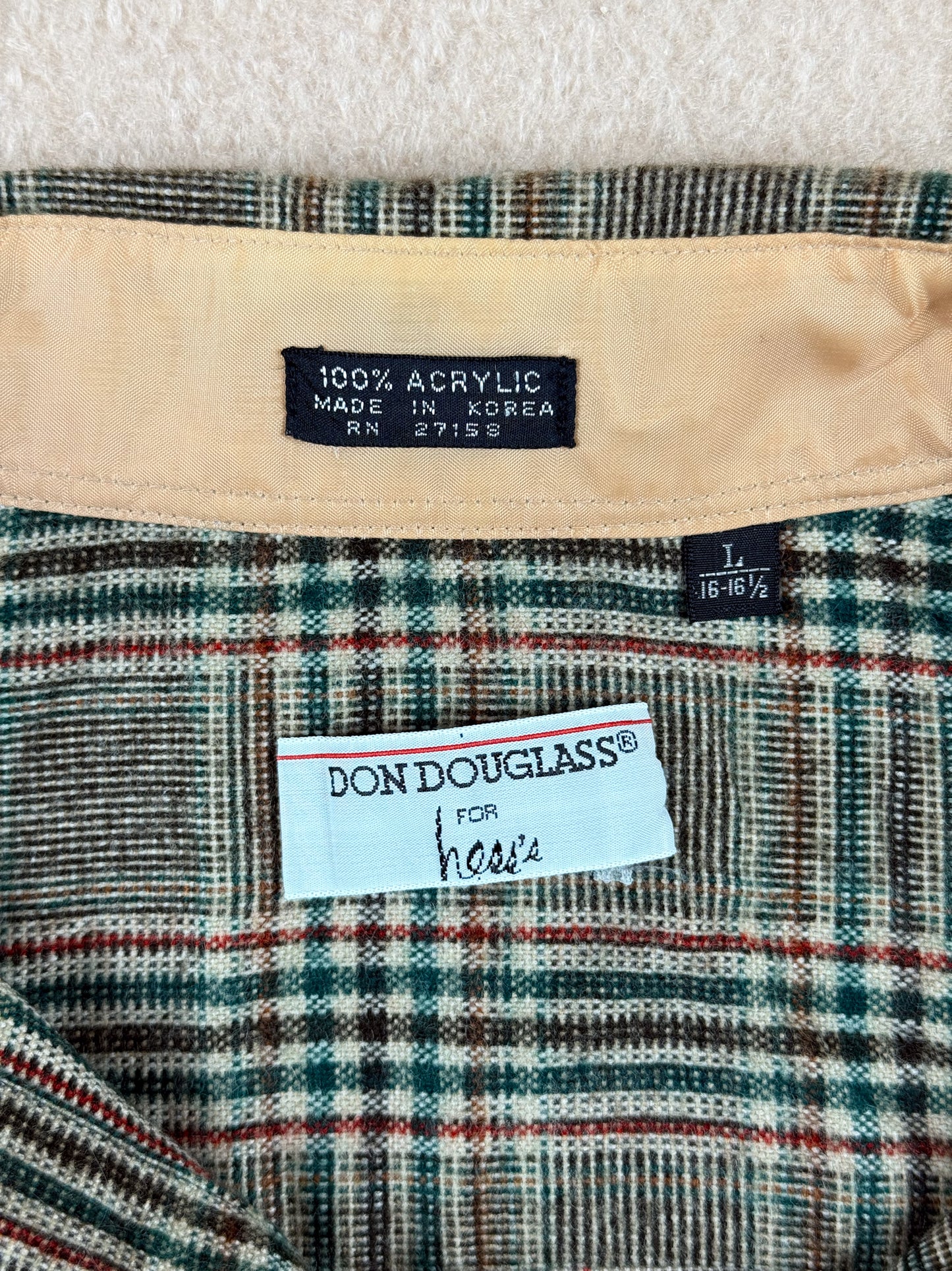 Close-up of a plaid fabric with a label and 'Don Douglass' branding.