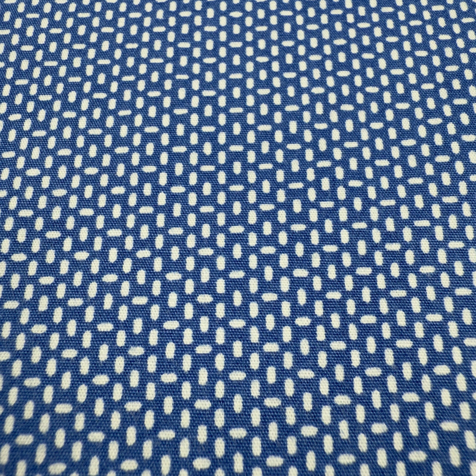 Close-up of white micro dot pattern on navy cotton shirt fabric